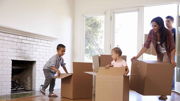 family having fun with boxes in their new home