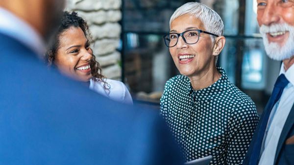 Senior executive woman smiling at her colleagues