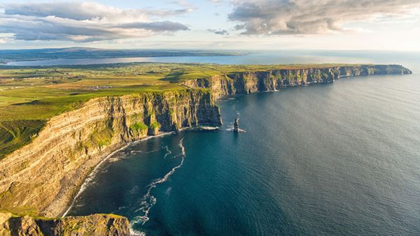 sun reflecting off cliffs of wild irish coastline