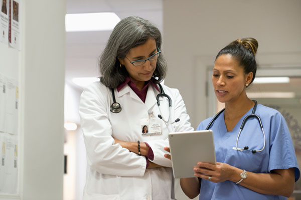 mixed race doctor discussing documents with nurse