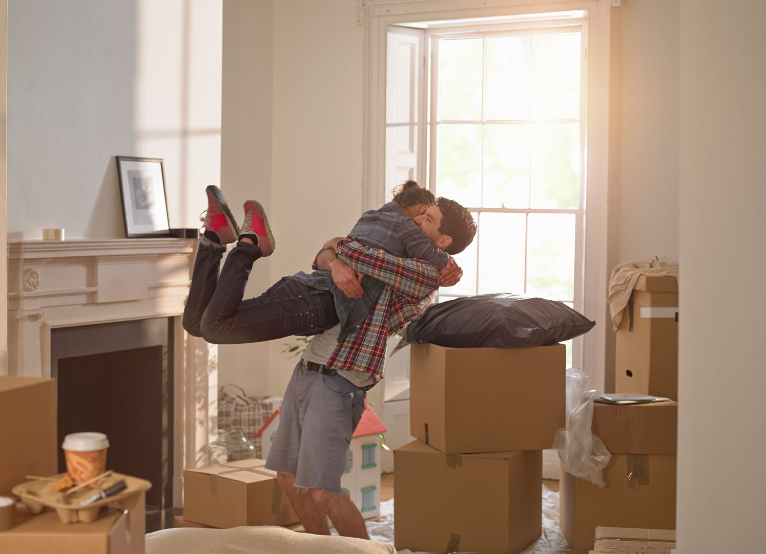 young man lifts his partner in excitement at moving into their new home