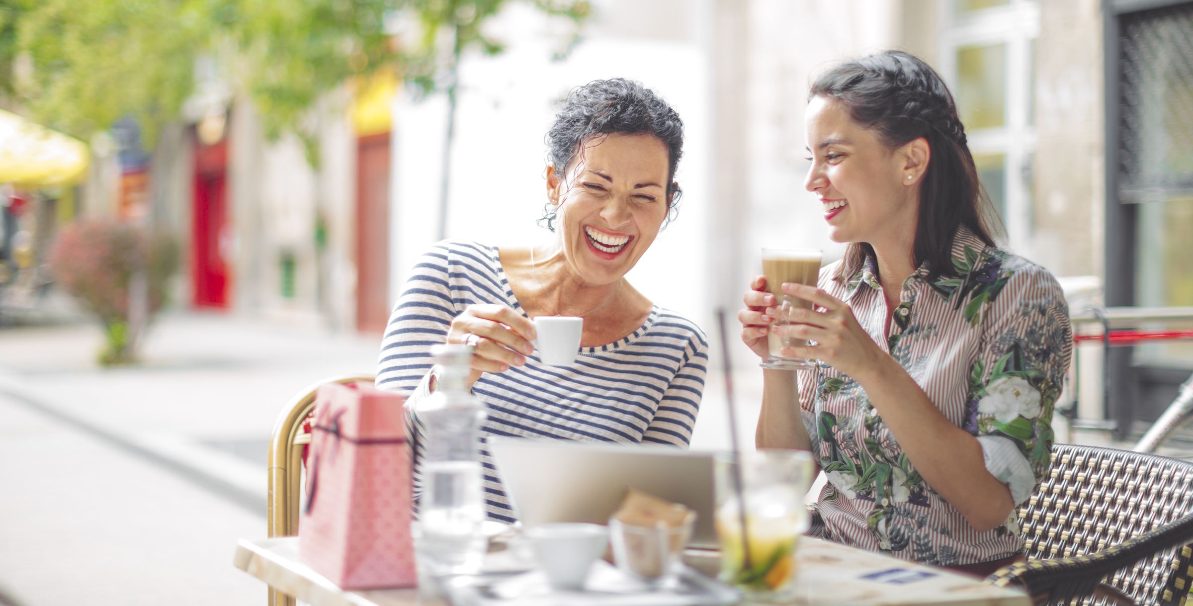 Two women laughing over coffee