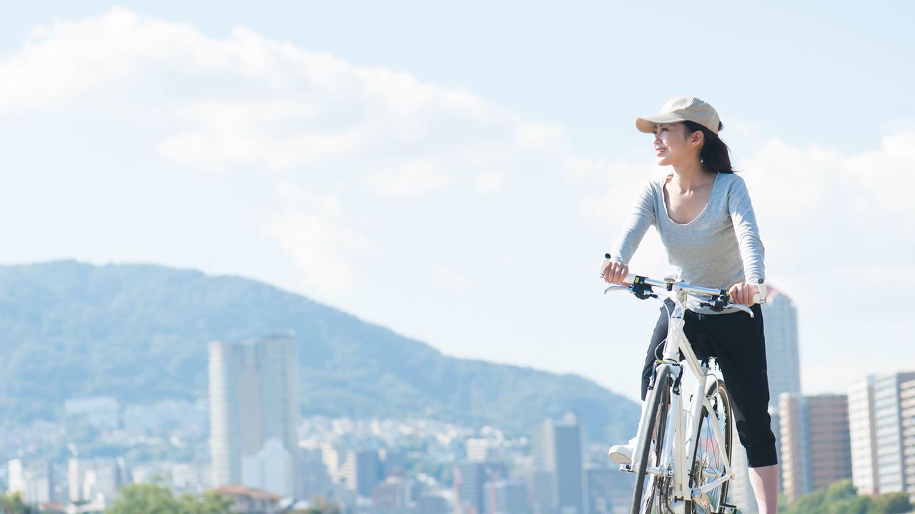 Woman on bike with city background