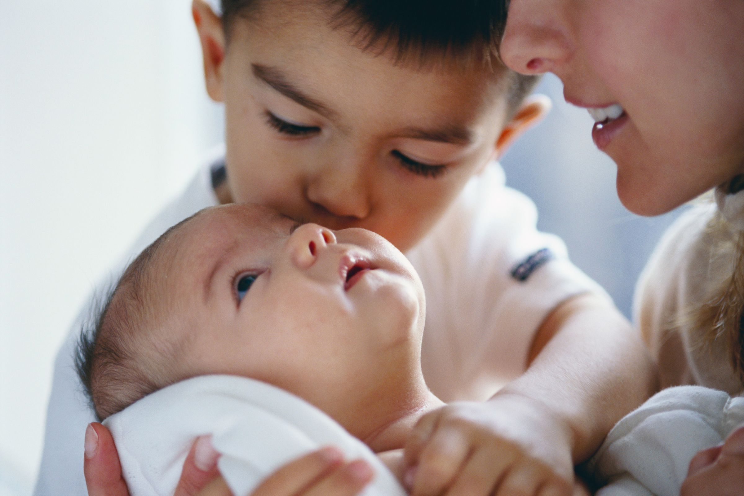 New born baby being kissed by brother